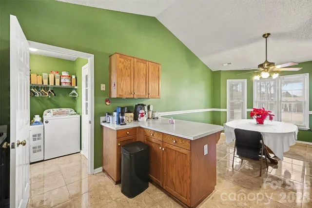 a view of a kitchen with fridge and workspace