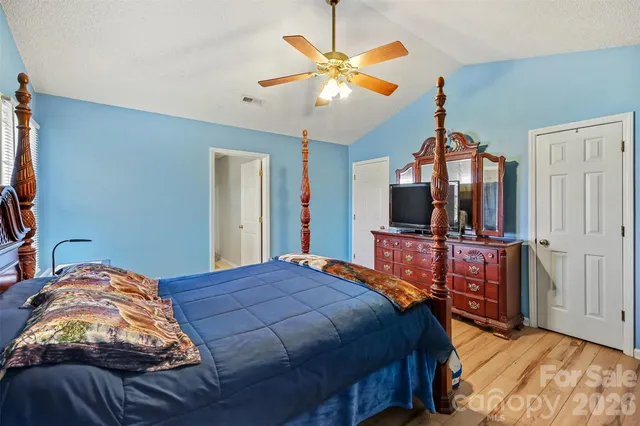 a bedroom with a bed and a flat tv screen on dresser