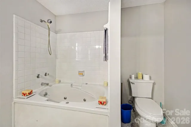 a white toilet sitting next to a bath tub