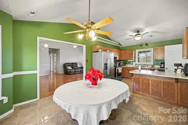 a kitchen with stainless steel appliances kitchen island a chandelier sink and stove