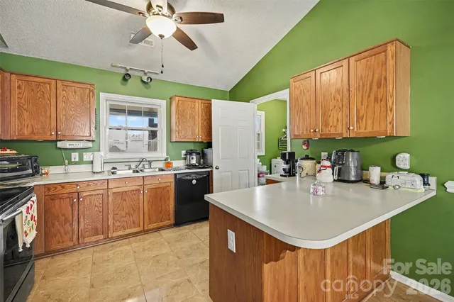 a kitchen with a sink a counter top space cabinets and stainless steel appliances