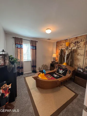 a spacious bedroom with a bed and lamp