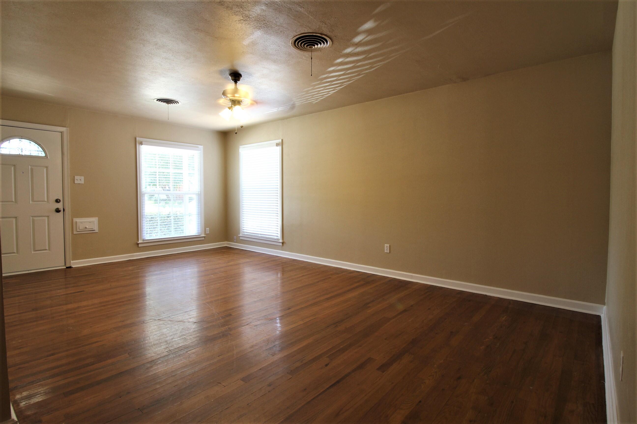 2208 32nd Street Lubbock, TX 79411 - Photo 4 of 14 an empty room with wooden floor and windows