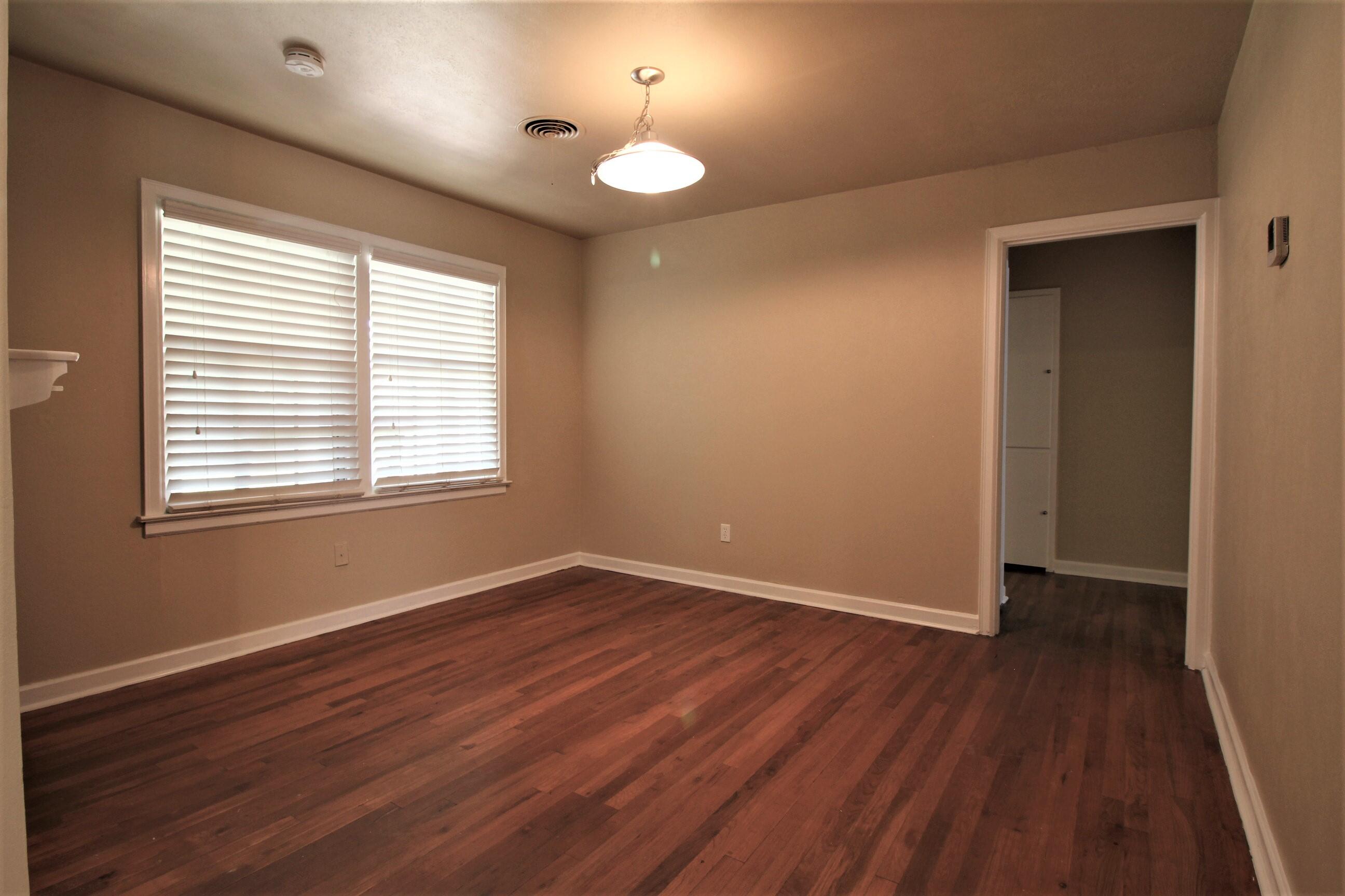 2208 32nd Street Lubbock, TX 79411 - Photo 5 of 14 an empty room with wooden floor and windows