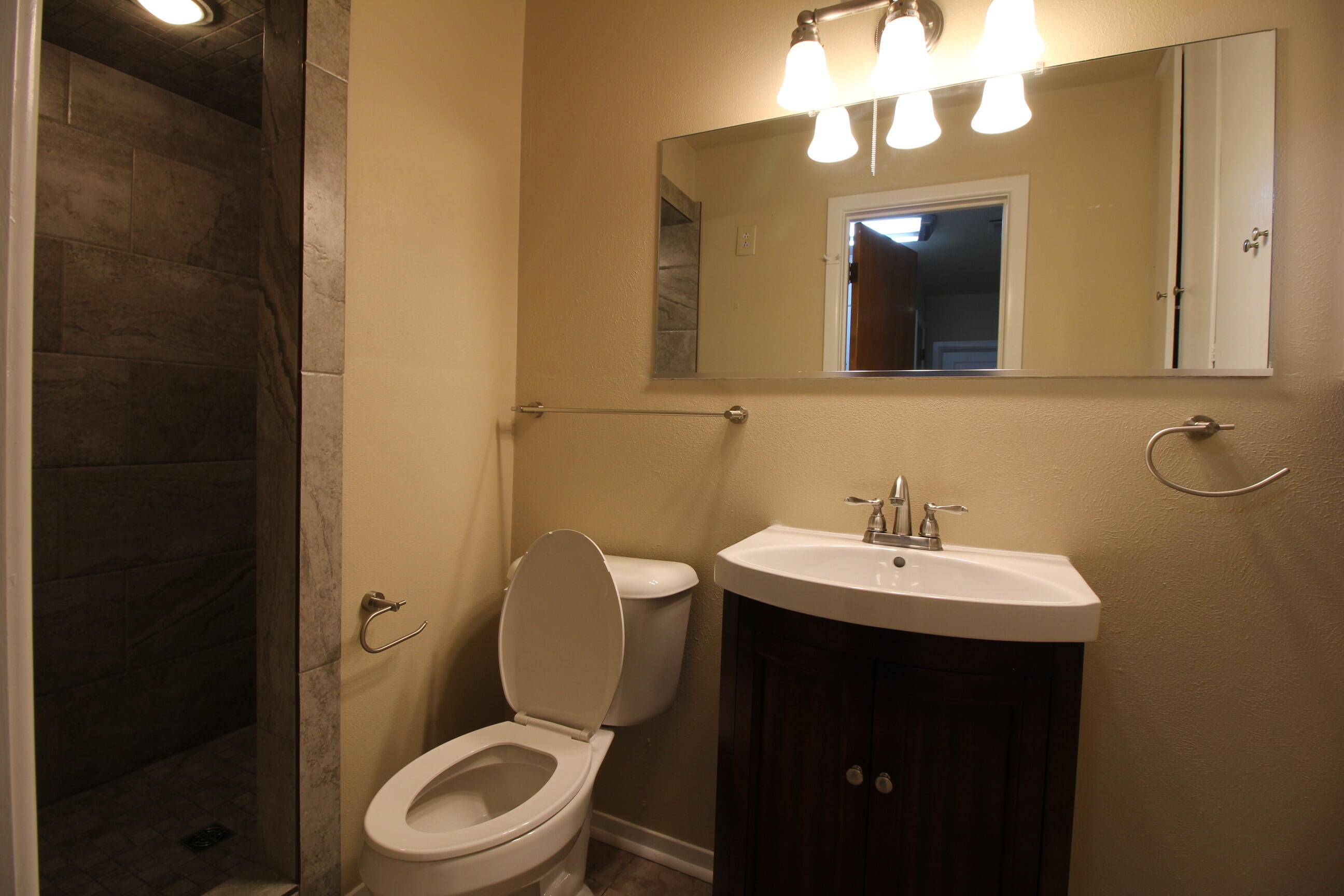 2208 32nd Street Lubbock, TX 79411 - Photo 7 of 14 a bathroom with a toilet sink and mirror