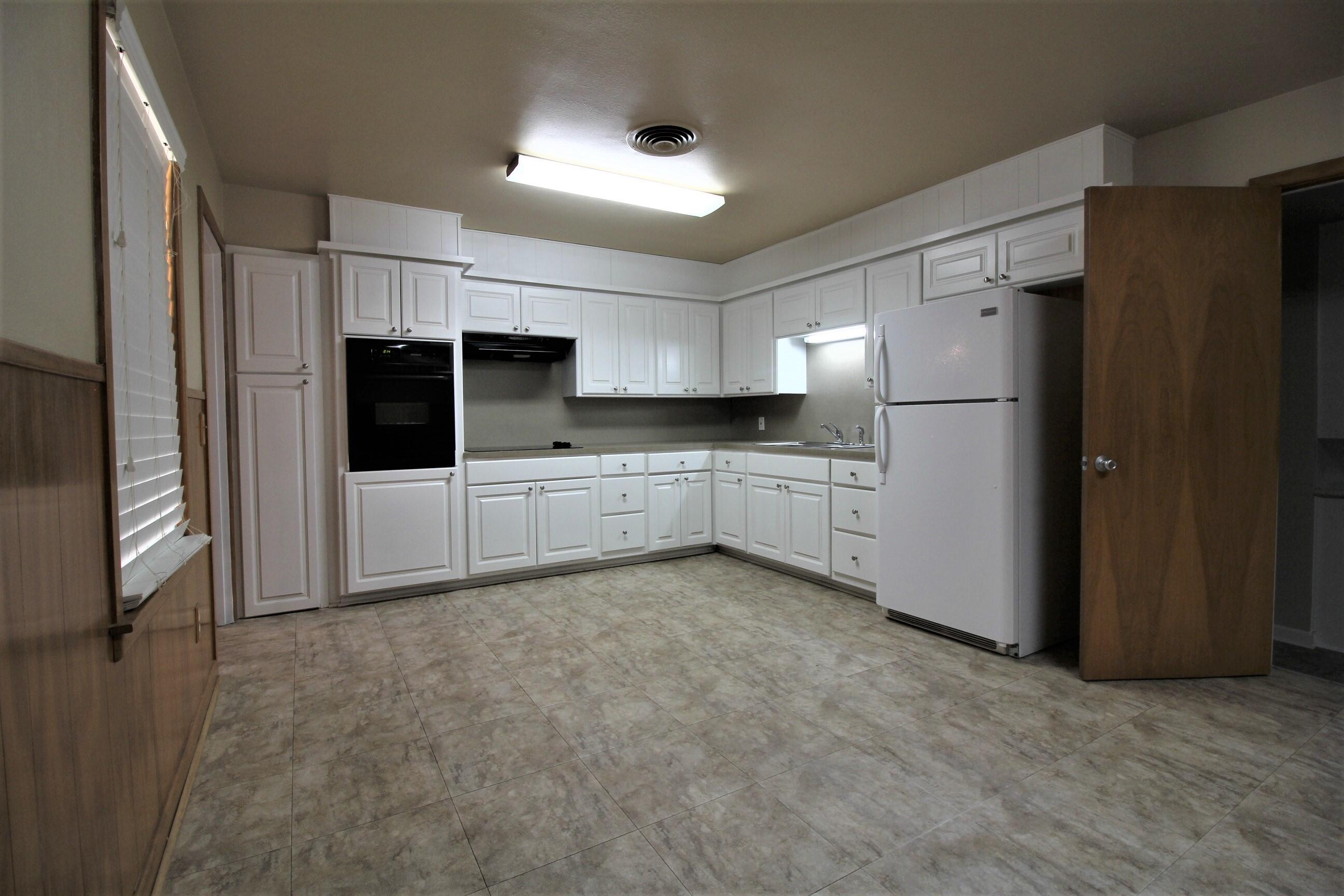 2208 32nd Street Lubbock, TX 79411 - Photo 10 of 14 a kitchen with stainless steel appliances a refrigerator and a stove top oven