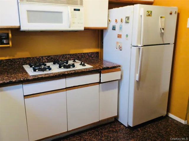 a white refrigerator freezer sitting inside of a kitchen