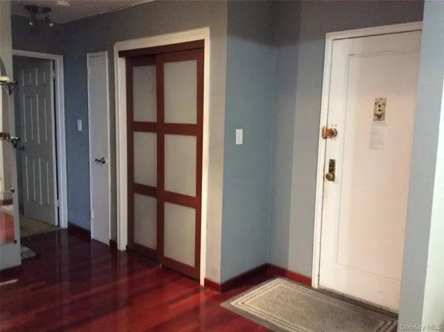 an empty room with wooden floor and entrance