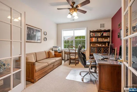 a living room with furniture a bookshelf and a window