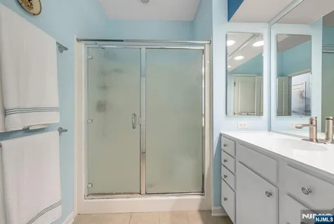a bathroom with a shower sink and mirror