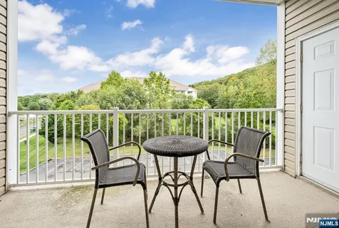 a view of a chairs and table in the balcony