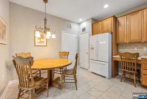a kitchen with stainless steel appliances a table chairs and refrigerator
