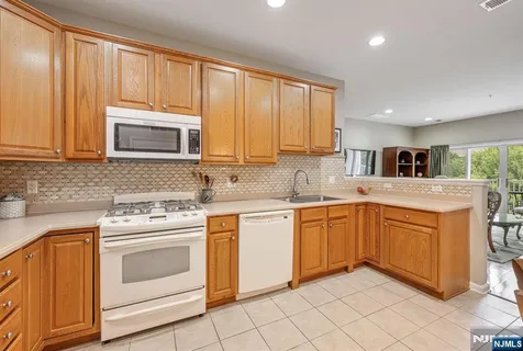 a kitchen with granite countertop cabinets stainless steel appliances and a window