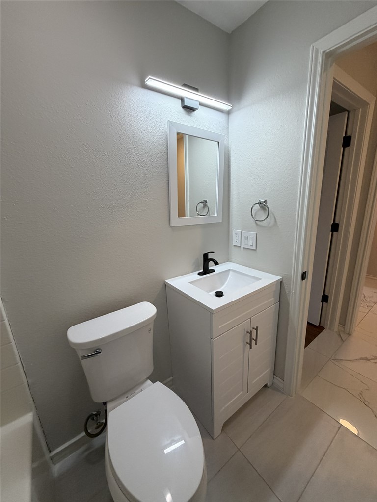 2839 Mckinzie Road, Unit 4 Corpus Christi, TX 78410 - Photo 25 of 31 a white toilet sitting next to a bathroom sink