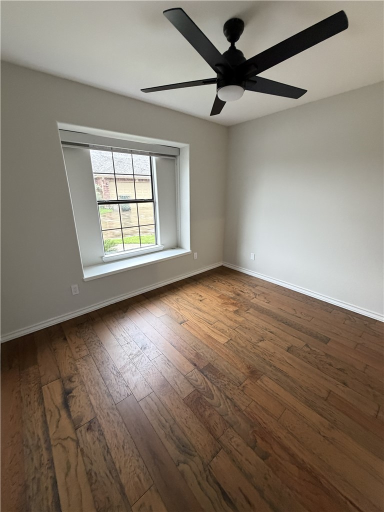 2839 Mckinzie Road, Unit 4 Corpus Christi, TX 78410 - Photo 27 of 31 an empty room with wooden floor fan and windows