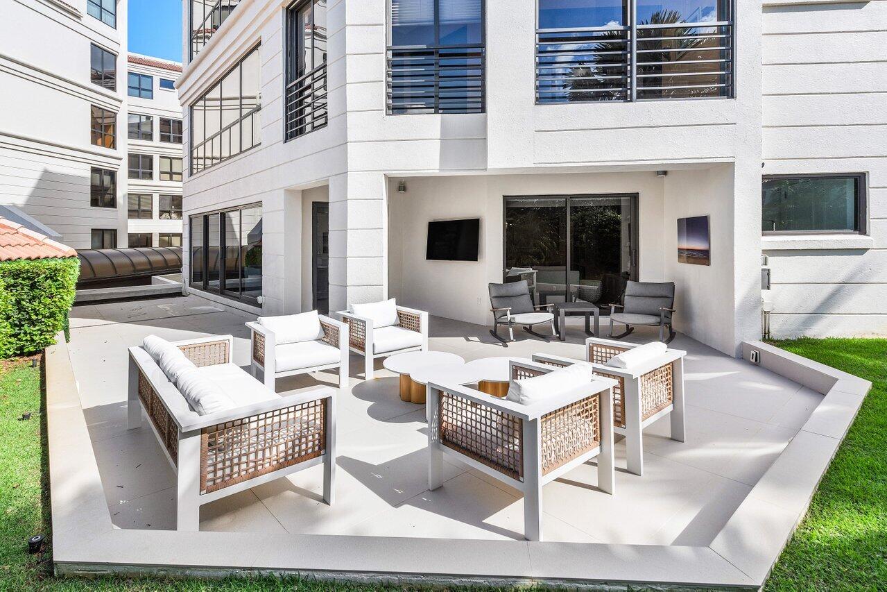 7383 Orangewood Lane, Unit 501 Boca Raton, FL 33433 - Photo 43 of 67 a view of a patio with couches table and chairs with wooden floor and fence