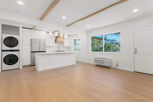 a view of a kitchen with a sink a refrigerator and window