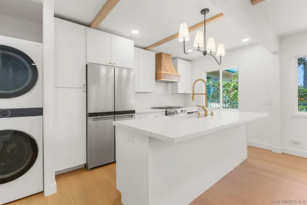a kitchen with a sink a refrigerator and a stove top oven