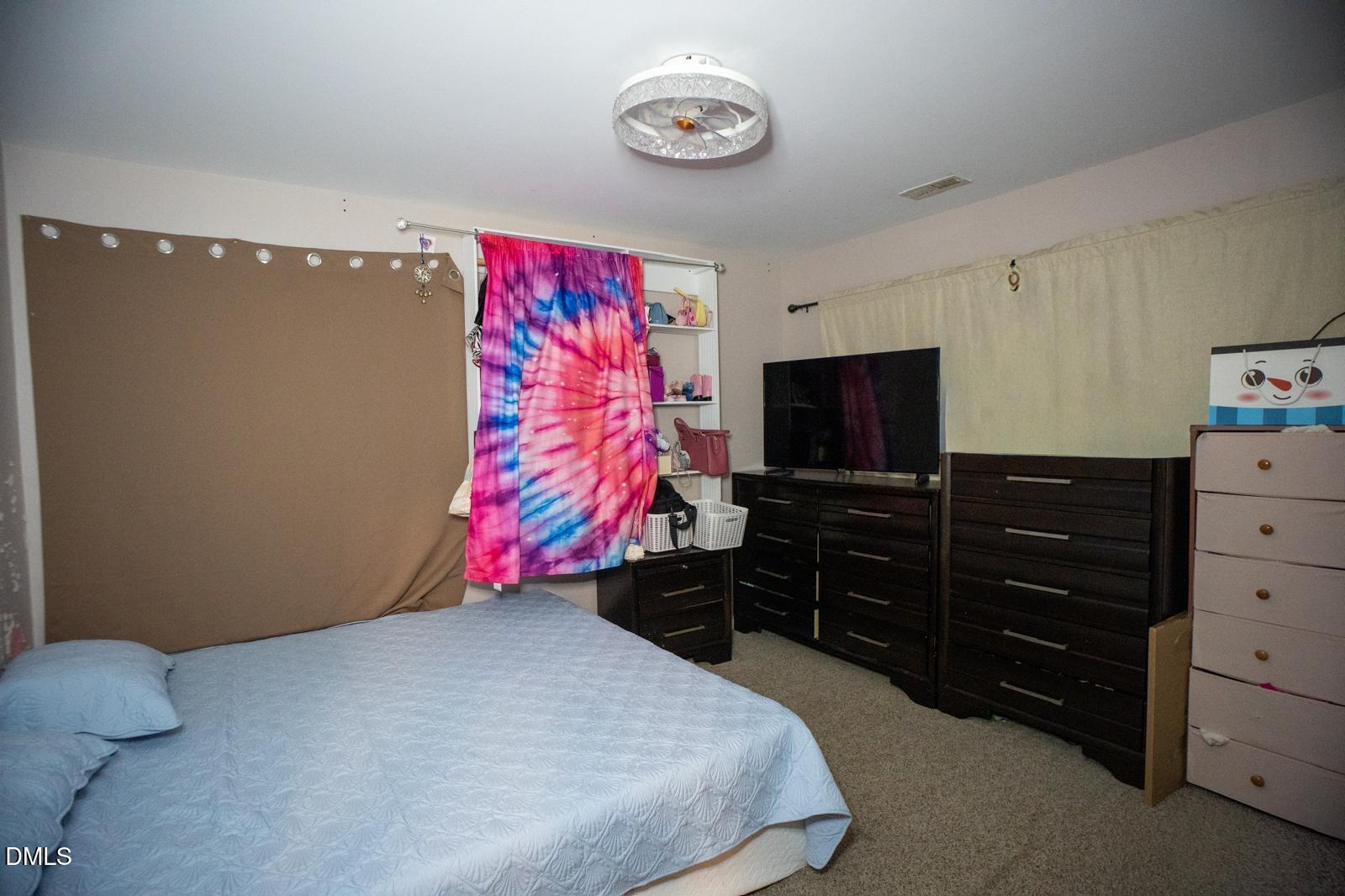 3304 Mackinac Island Lane Raleigh, NC 27610 - Photo 15 of 30 a bedroom with a bed and a flat screen tv