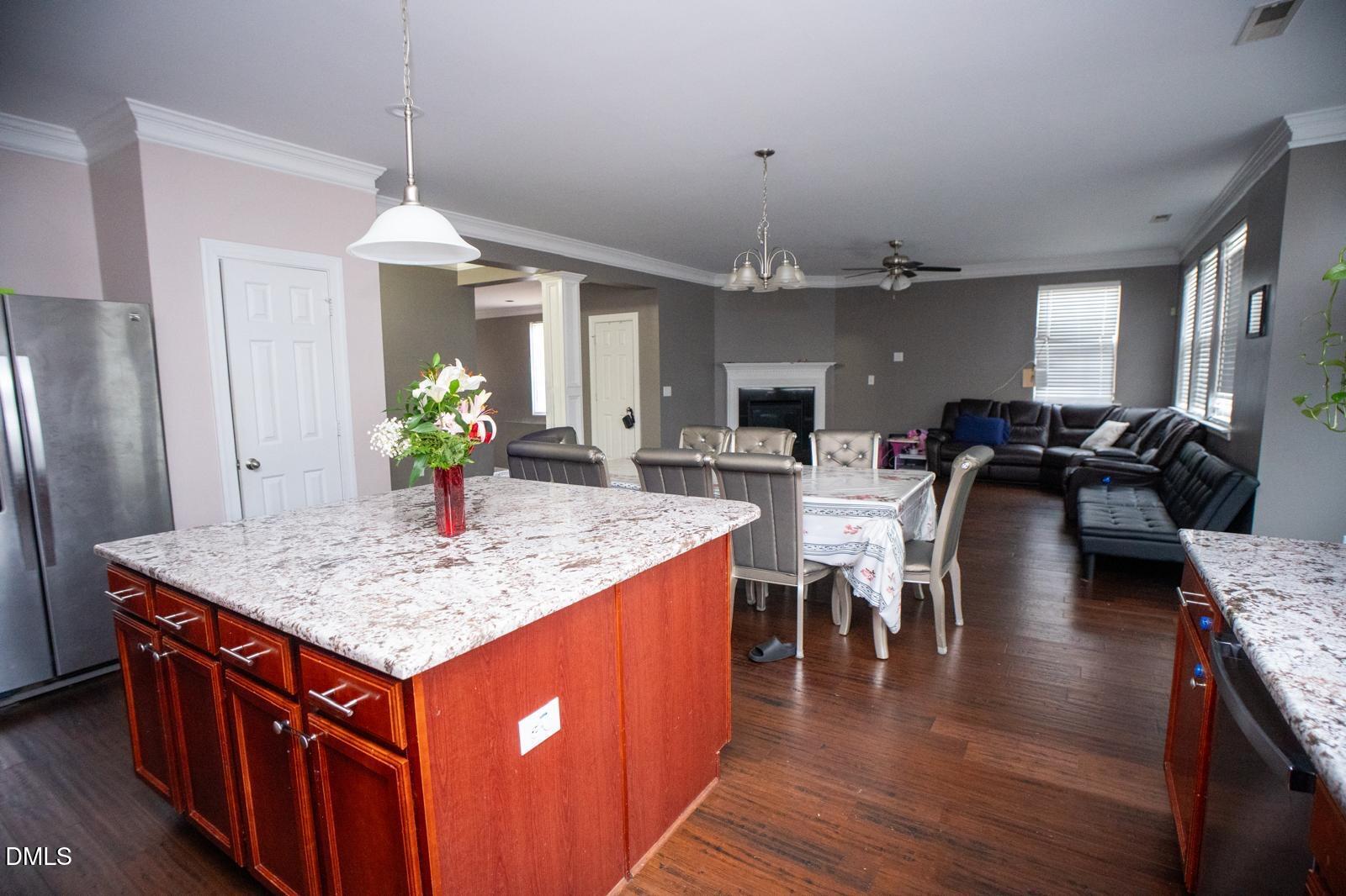 3304 Mackinac Island Lane Raleigh, NC 27610 - Photo 5 of 30 a kitchen with stainless steel appliances granite countertop a kitchen island a stove a table and chairs
