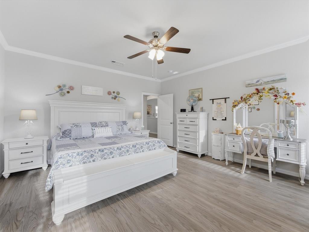 129 Springwood Ranch Loop Springtown, TX 76082 - Photo 21 of 26 Spacious room featuring light wood-finish flooring, crown molding, and a ceiling fan with integrated lighting