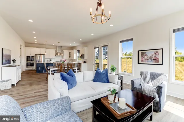 a living room with furniture kitchen view and a dining table