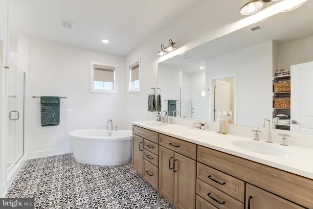 a spacious bathroom with a double vanity sink a mirror and a bathtub