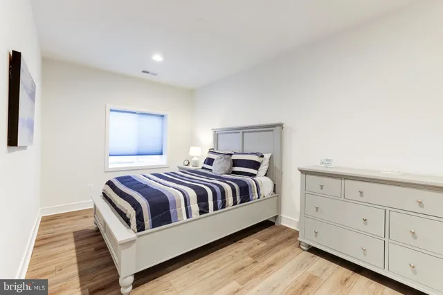 a spacious bedroom with a bed and cabinet