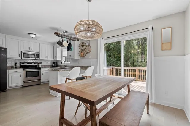 a view of a dining room with furniture a chandelier and wooden floor