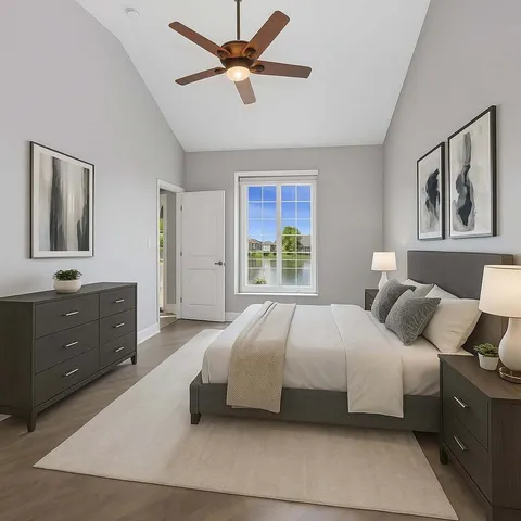a bedroom with a large bed and a chandelier