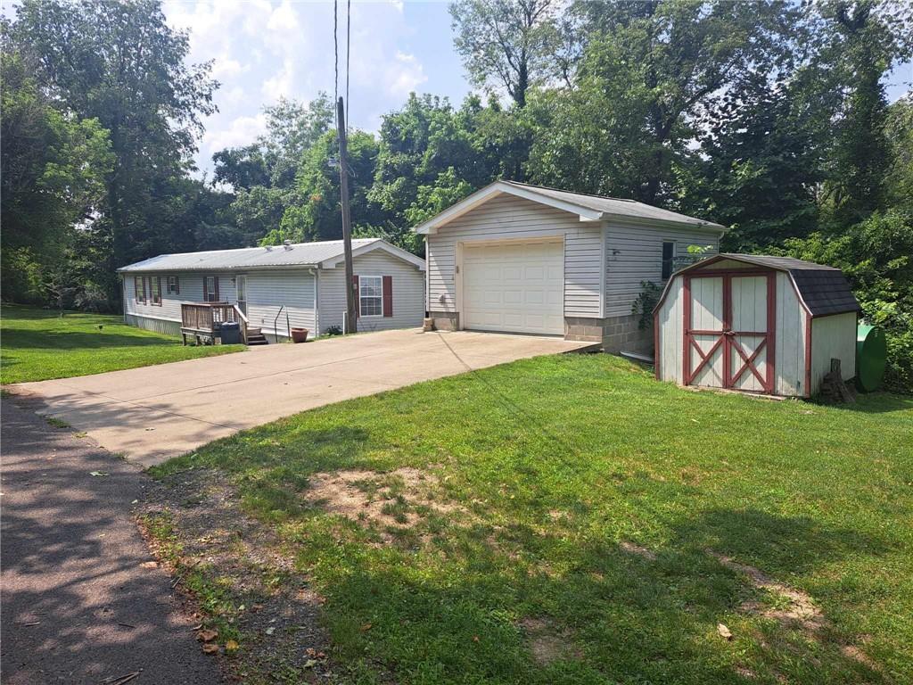 a view of a house with a yard and large trees