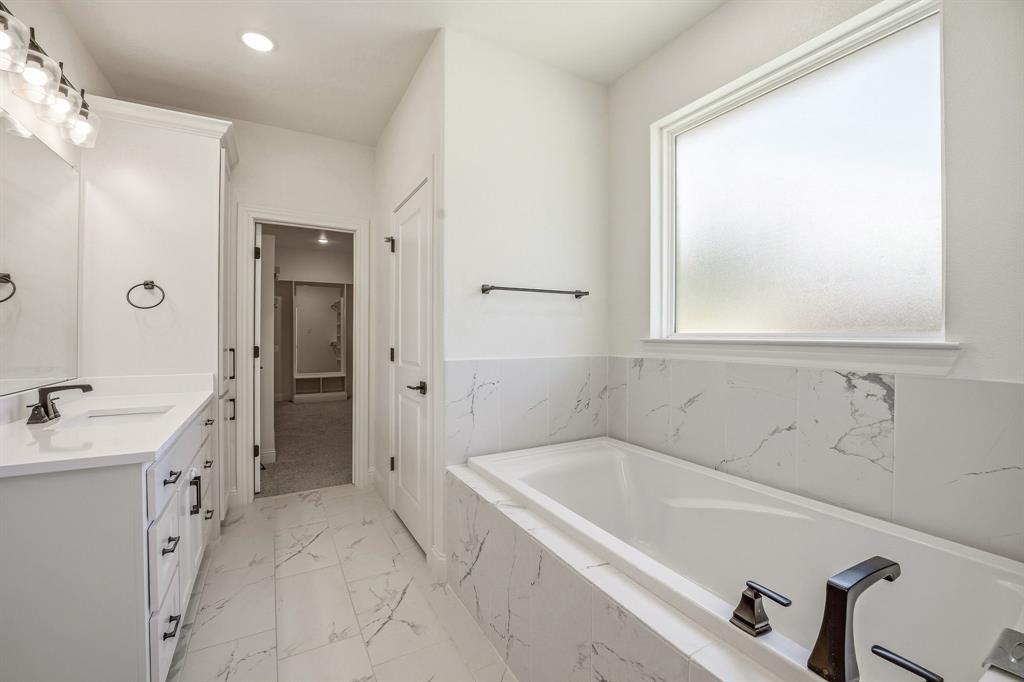 445 Rodeo Way Stephenville, TX 76401 - Photo 15 of 40 a spacious bathroom with a tub sink and mirror