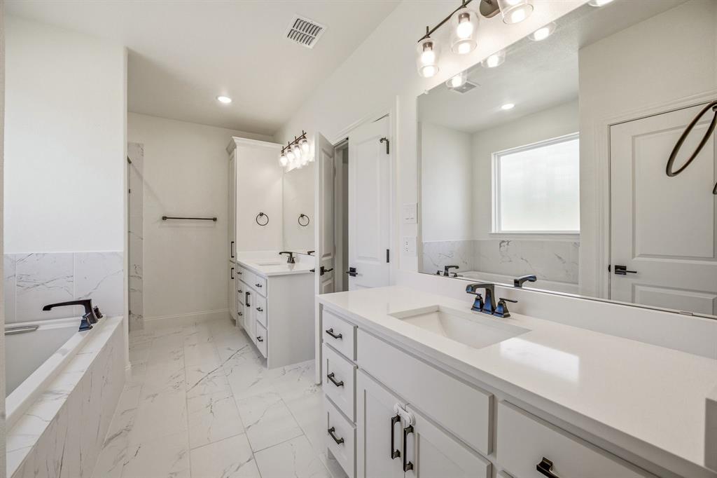 445 Rodeo Way Stephenville, TX 76401 - Photo 16 of 40 a bathroom with a double vanity sink toilet and shower
