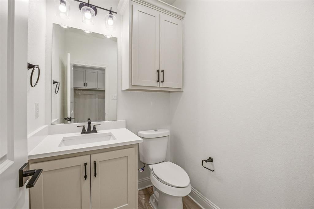 445 Rodeo Way Stephenville, TX 76401 - Photo 20 of 40 a bathroom with a toilet sink vanity and mirror