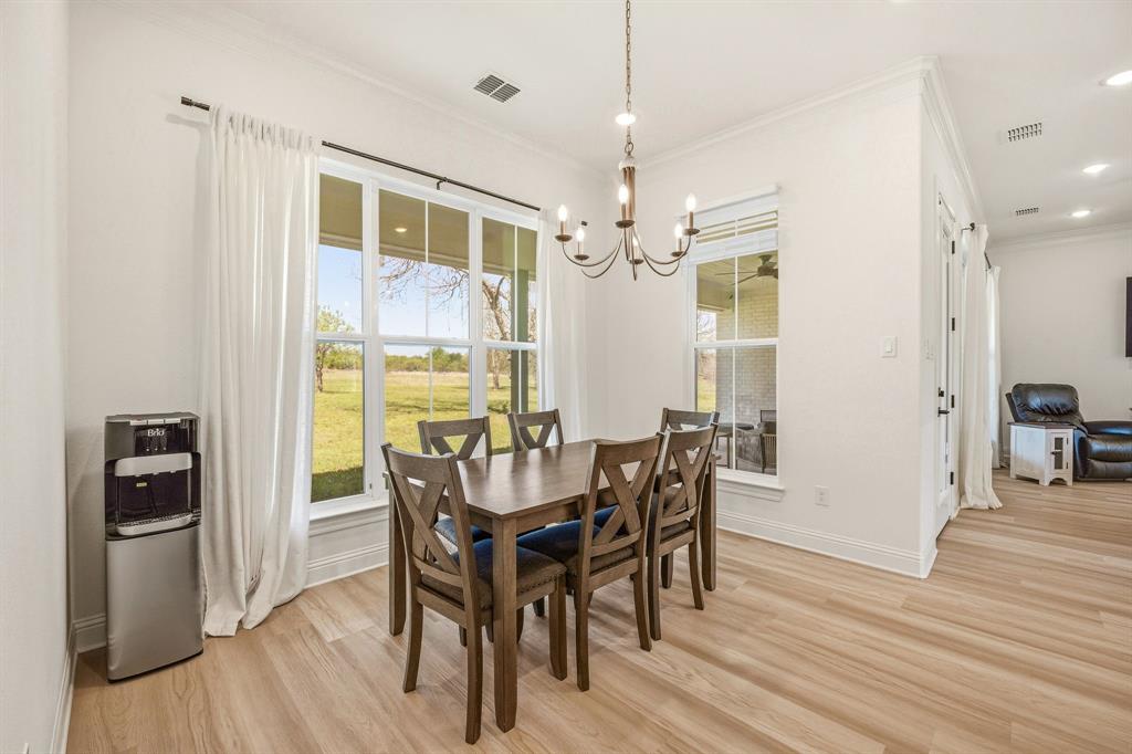 445 Rodeo Way Stephenville, TX 76401 - Photo 4 of 40 a view of a dining room with furniture and wooden floor