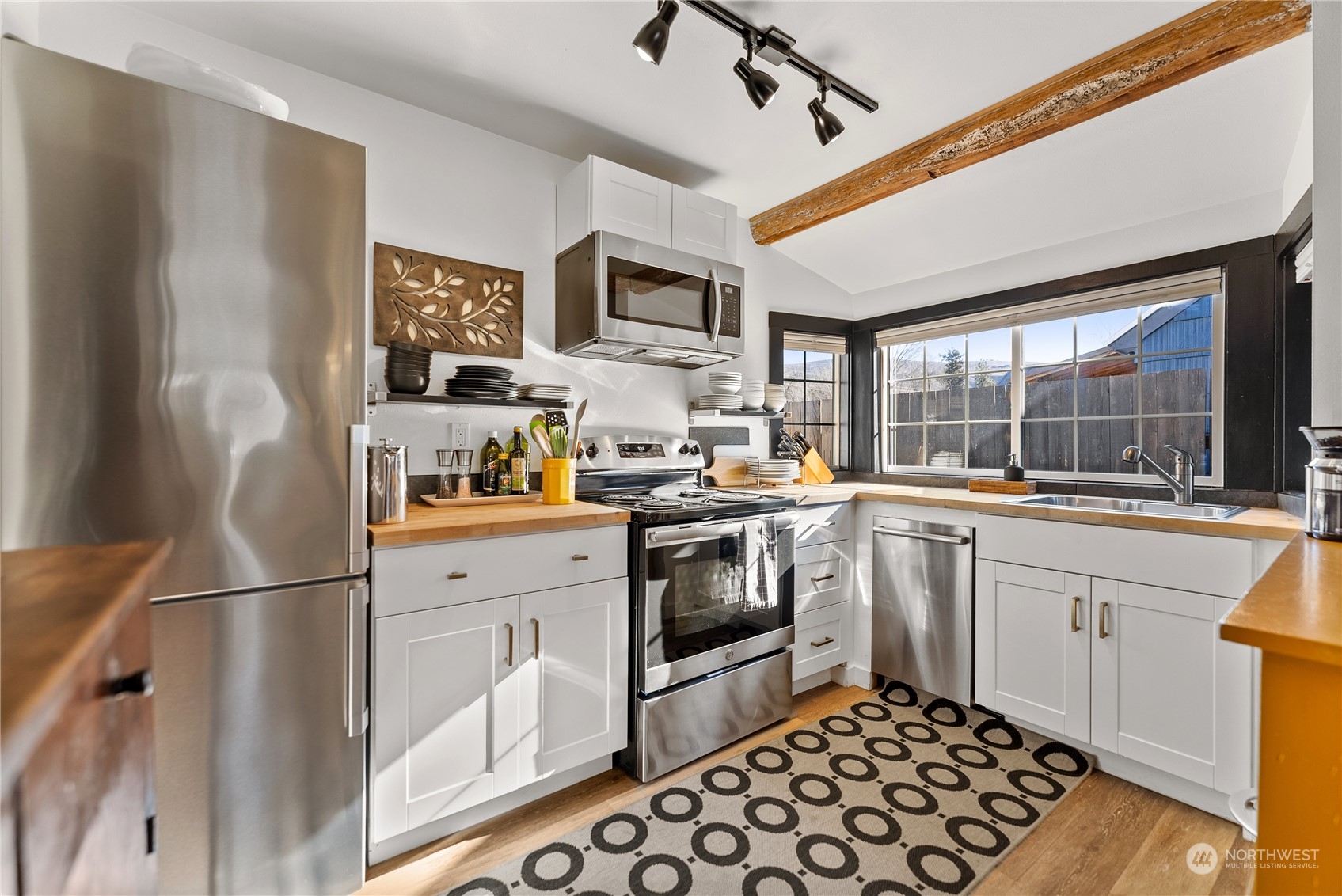 238 Castle Avenue Winthrop, WA 98862 - Photo 11 of 40 a kitchen with stainless steel appliances granite countertop a refrigerator a sink dishwasher a stove and white cabinets with wooden floor