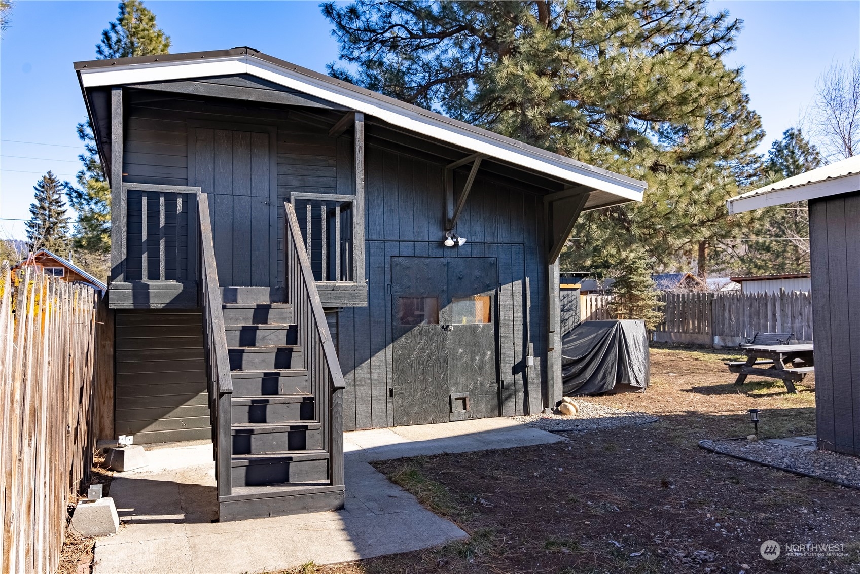 238 Castle Avenue Winthrop, WA 98862 - Photo 32 of 40 a view of a wooden house with a large window and potted plants