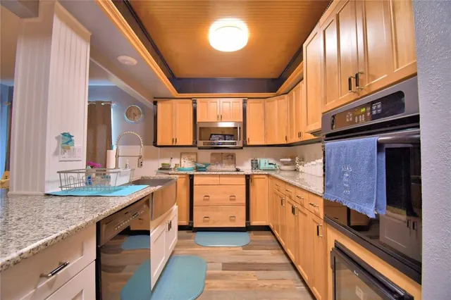 a kitchen with stainless steel appliances granite countertop a sink a stove and cabinets