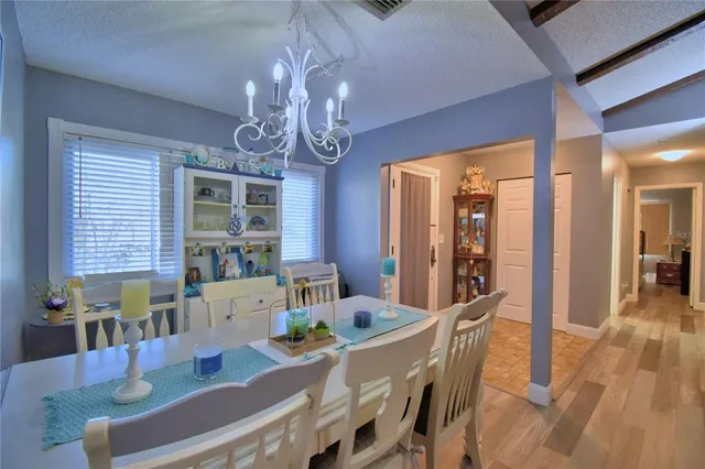 a view of a dining room with furniture a chandelier and wooden floor