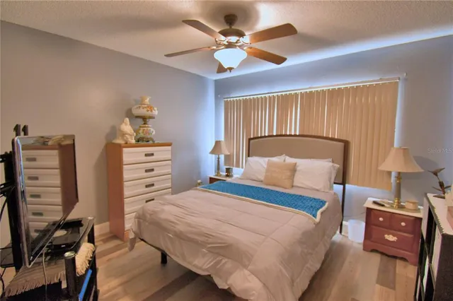 a bedroom with a bed a chandelier and a dresser