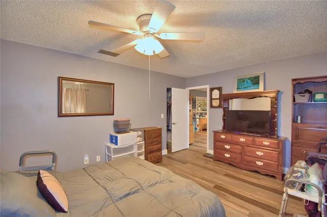 a bedroom with a bed and a flat tv screen on dresser