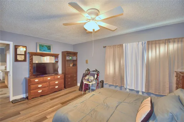 a bedroom with a bed and a tv on dresser