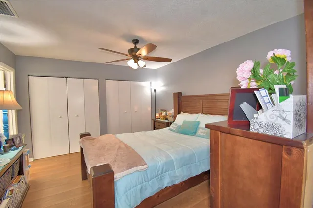 a bedroom with a bed a chandelier and a dresser