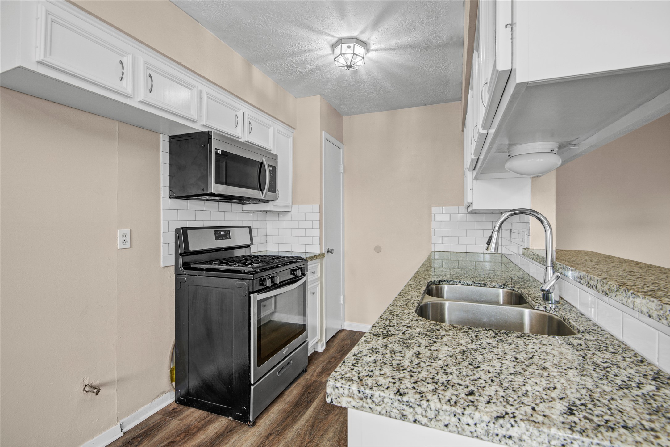 1230 Epsilon Street Pasadena, TX 77504 - Photo 13 of 27 a kitchen with stainless steel appliances granite countertop a stove a sink and a microwave