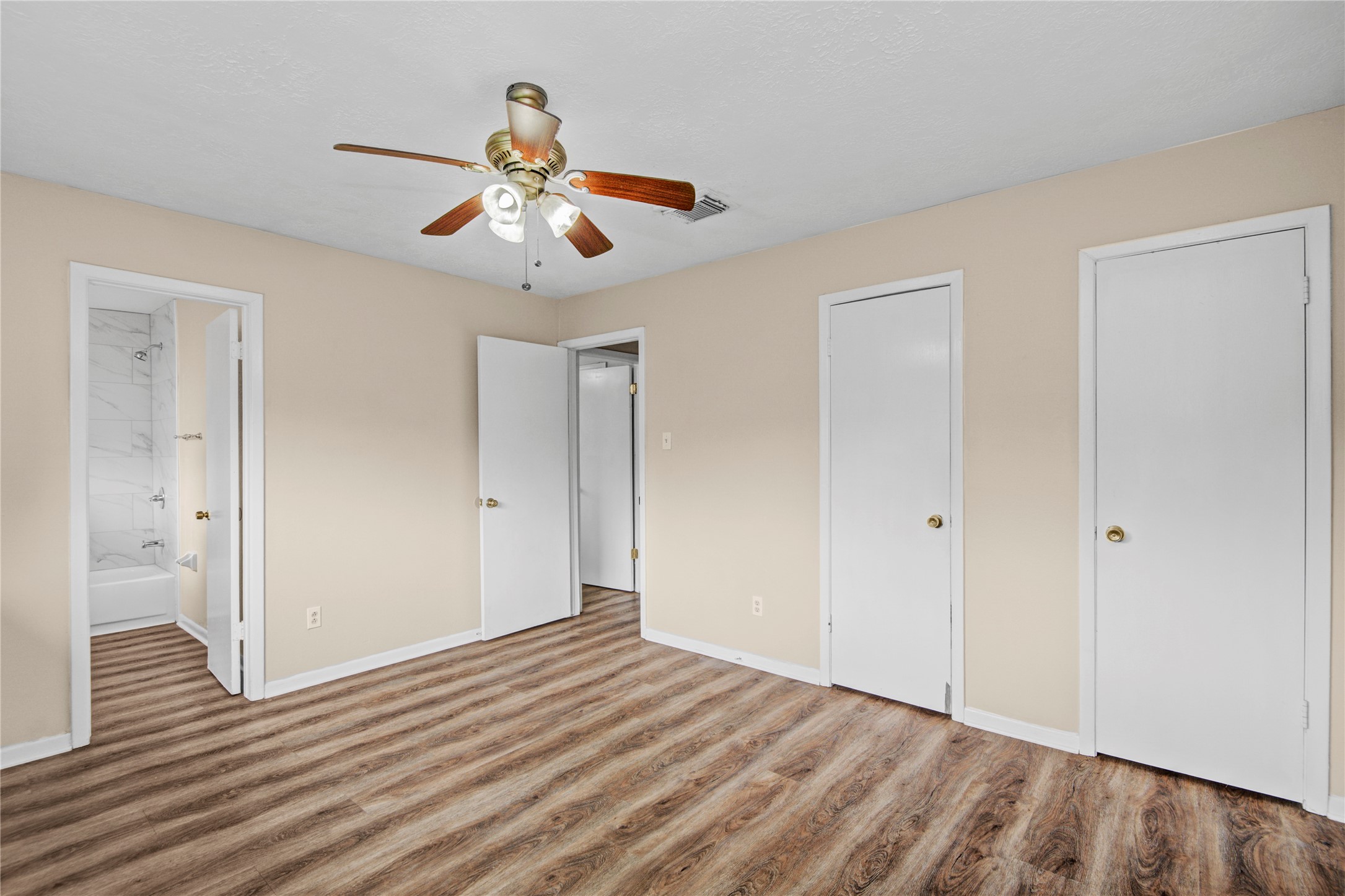 1230 Epsilon Street Pasadena, TX 77504 - Photo 22 of 27 a view of an empty room with wooden floor and a ceiling fan