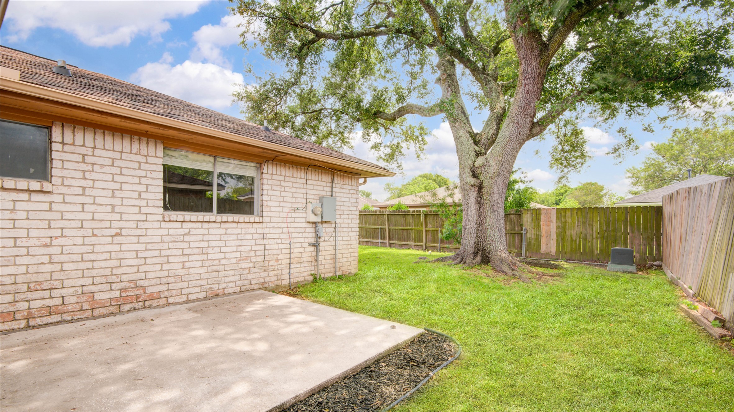 1230 Epsilon Street Pasadena, TX 77504 - Photo 24 of 27 a view of a backyard with a large tree