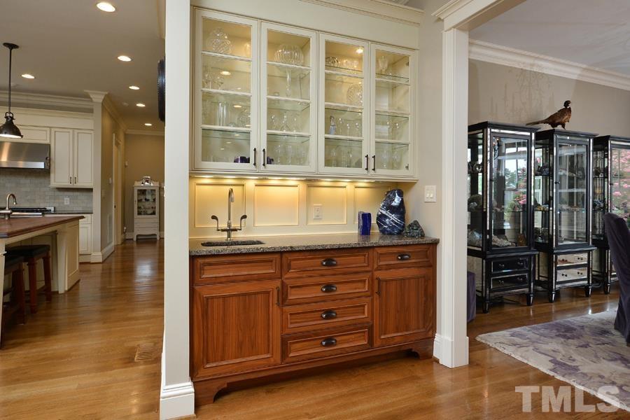 7 Springhouse Place Durham, NC 27705 - Photo 16 of 30 a kitchen with granite countertop a stove and a wooden cabinets