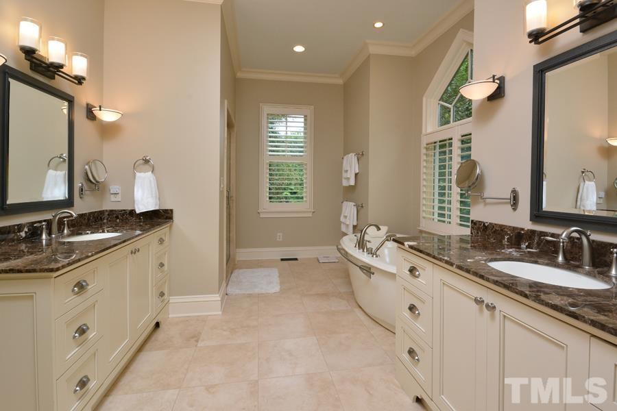 7 Springhouse Place Durham, NC 27705 - Photo 21 of 30 a spacious bathroom with a granite countertop double vanity sink a mirror and a bathtub