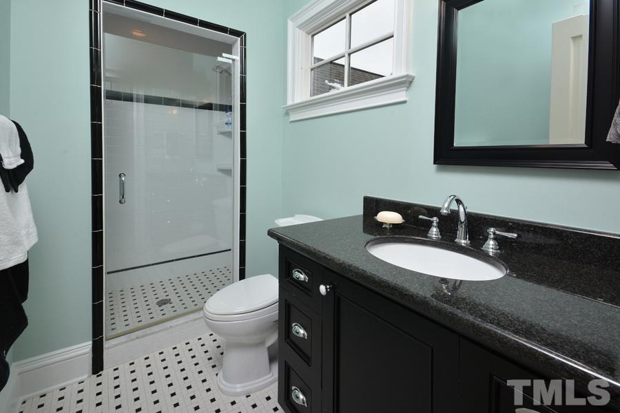 7 Springhouse Place Durham, NC 27705 - Photo 26 of 30 a bathroom with a granite countertop sink toilet a mirror and shower