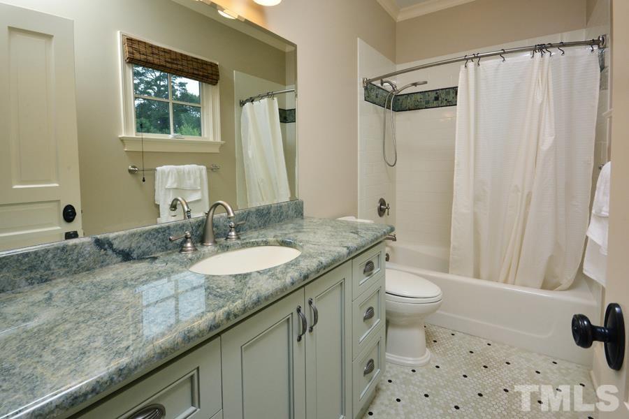 7 Springhouse Place Durham, NC 27705 - Photo 27 of 30 a bathroom with a granite countertop sink a toilet a mirror a vanity and shower